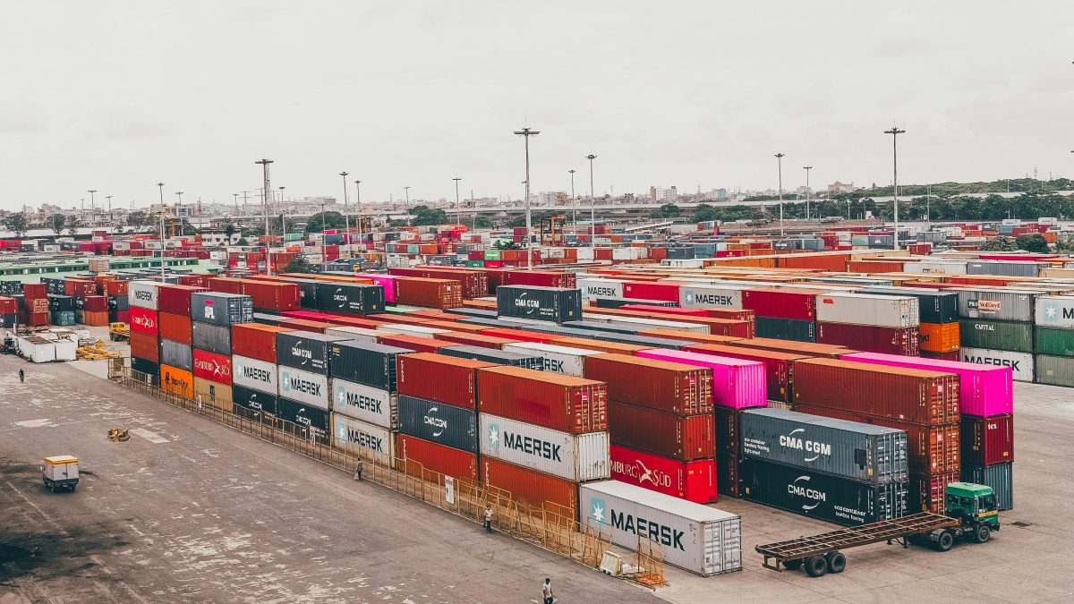 A stack of shipping containers at a busy seaport, symbolizing secure international trade facilitated by Bank Payment Undertaking (BPU).