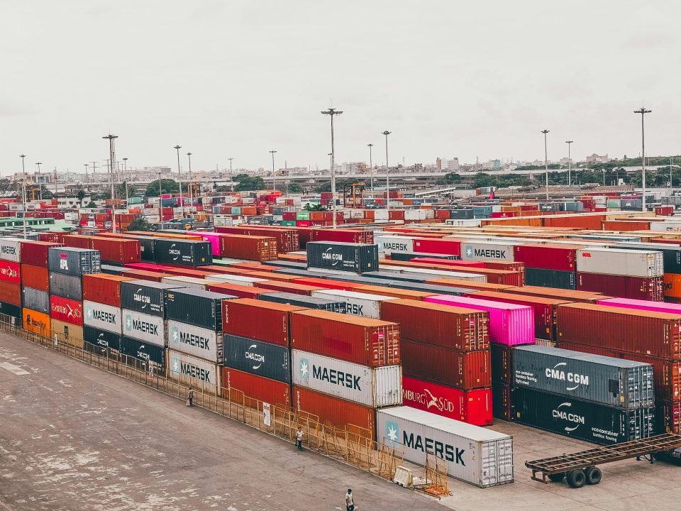 A stack of shipping containers at a busy seaport, symbolizing secure international trade facilitated by Bank Payment Undertaking (BPU).